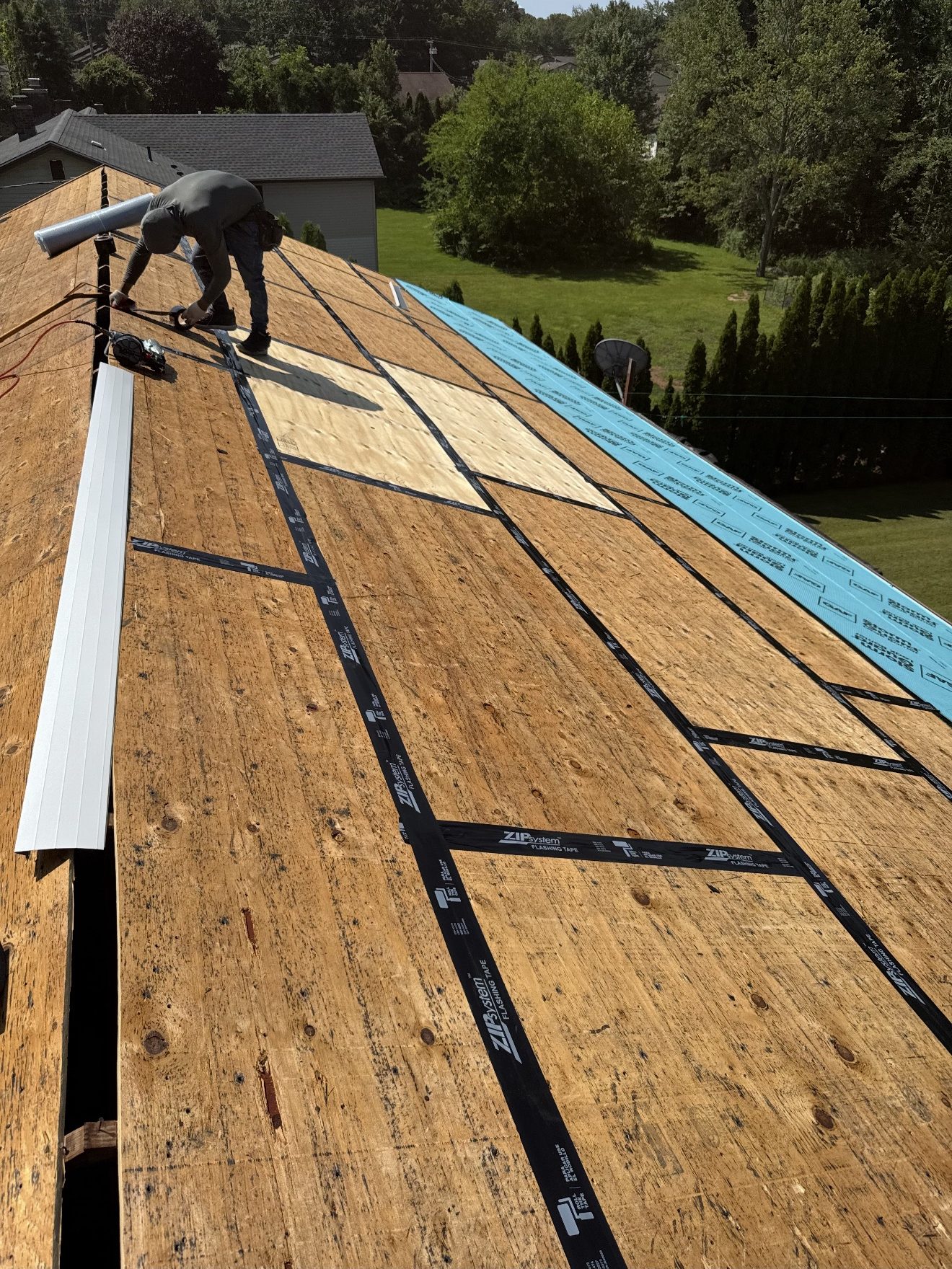 Crew member installing new plywood roof decking and sheathing on a Connecticut home